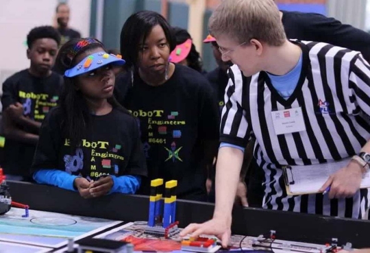 RICHMOND, Va. -- Naval Surface Warfare Center Dahlgren Division (NSWCDD) engineer Serita Seright, 2nd from right, and a student, listen to a judge explain the FIRST LEGO League (FLL) competition rules and point system at Maggie Walker Governor High School in November 2015. Seright—who mentors a FLL student team called the "Robot Engineers"—was honored by the National Society of Black Engineers (NSBE) as the Region II "Professionals Member of the Year" for leadership impacting its mission in Virginia, NSWCDD announced, May 16. "I'm humbled to be recognized for personifying the NSBE mission—to increase the number of culturally responsible black engineers who excel academically, succeed professionally, and positively impact the community," said Seright, in response to the news. The award recognizes individuals who make outstanding contributions to NSBE, especially their chapter and region, in the areas of leadership, excellence, service, and advancement of its programs and mission.