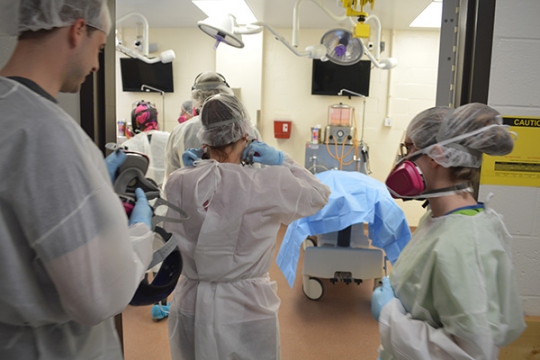 Students from The Community College of Baltimore County crowd around two donated bodies at the University of Maryland School of Medicine, April 5, 2016. They wear protective face gear to protect themselves from formaldehyde that can cause upper respiratory problems. (Photo: Leo Traub)