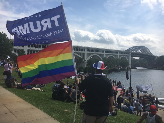 Eddy Dee, a member of Democrats for Trump, flies both a Pride and Donald Trump flag at the America First Unity First Rally 2016 outside of the Republican National Convention. (Capital News Service photo by Josh Magness)