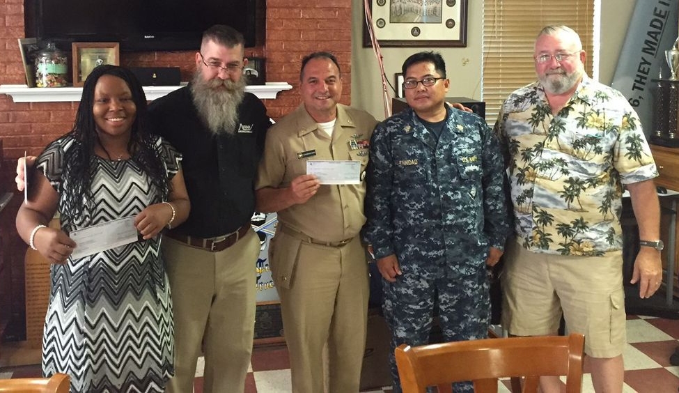 
ASCS (AW/SW) Hope Kulaszewski, left, and NCCM (AW/SW) Mike Sekeet, center, accept checks from members of the Patuxent River Chief Petty Officers Association Scholarship Committee on behalf of their daughters, Stephanie and Ciara, who were awarded scholarship money July 6. (Photo courtesy Patuxent River Chief Petty Officers Association)