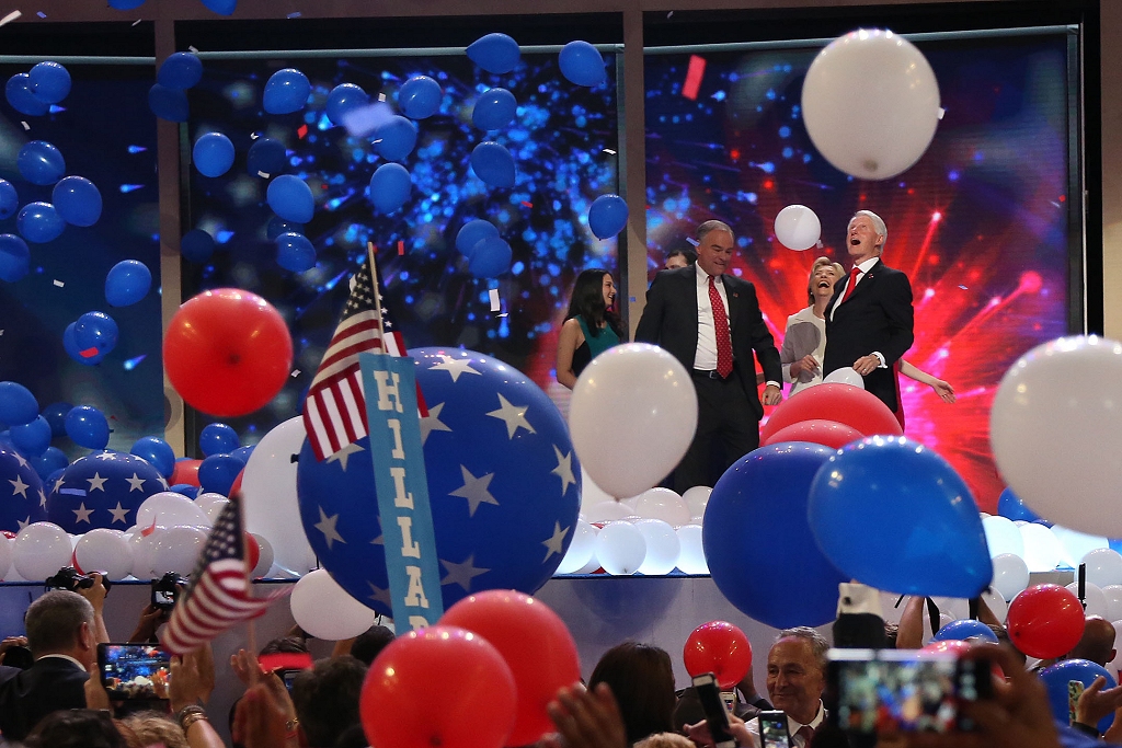Tim Kaine, Hillary Clinton and Bill Clinton celebrate as balloons drop on the Democratic National Convention stage and floor after Hillary Clinton's acceptance speech Thursday. (Photo: Hannah Klarner)