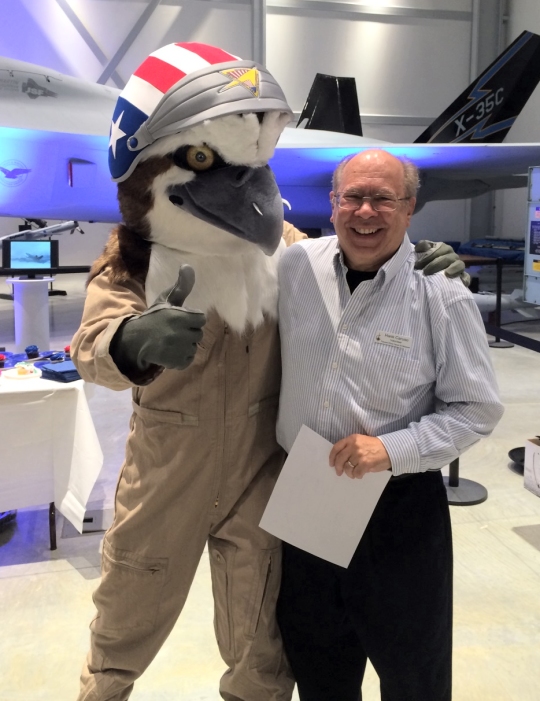 Patuxent River Naval Air Museum's new mascot Oscar Falco meets his creator, aviation artist and honorary naval aviator, Hank Caruso at the museum's recent volunteer appreciation dinner. Pax Museum photo by Jane Macone.