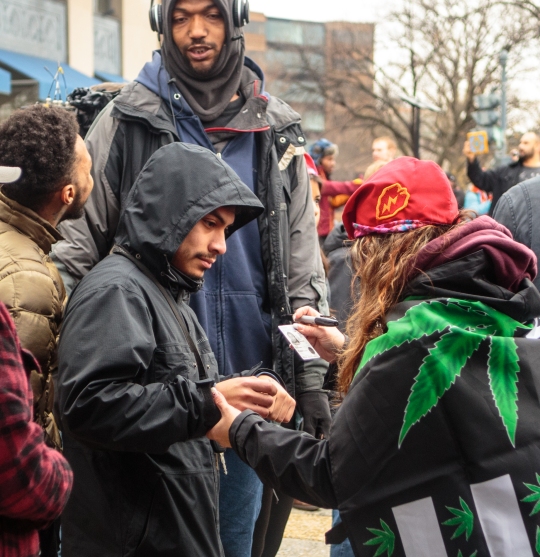 A patron has his ID card checked for a second time at the DCMJ #TRUMP420 event in Dupont Circle, ensuring that everyone who received a free joint did so legally on Friday, Jan. 20, 2017. (Photo: Tom Hausman)