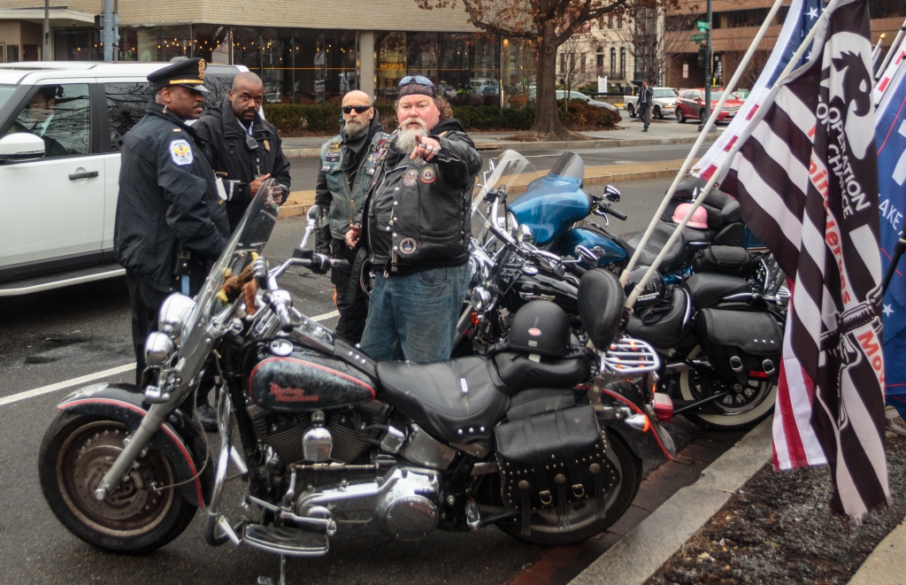 A member of the “Let America hear us, roar for Trump!” biker group talks to police about where the group could park their bikes in Dupont Circle, following their counter-protest at the DCMJ #TRUMP420 event on Friday, Jan. 20, 2017. Three different biker groups were set to ride through the District, intending to block people who were protesting President Donald Trump. (Photo: Tom Hausman)