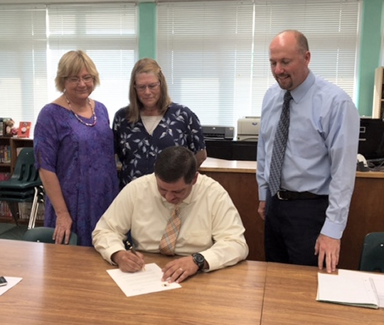 Pictured from left to right: Ann K ovalcik, SCNA, Sister Valarie Miller, SCN, Principal Tony Wojt (seated) and Jerry Spence, president of the MCA board of trustees.