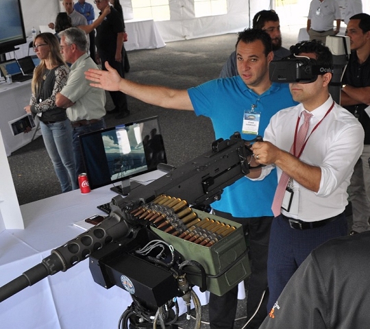 DAHLGREN, Va. (Sept. 14, 2017) - A visitor wearing augmented reality glasses at the 2017 Annual Navy Technology Exercise (ANTX) engages in mixed reality training as he fires on fast attack craft and fast inshore attack craft (FAC-FIAC) with an M-2HB .50 caliber machine gun simulator. The FAC/FIAC Integrated Training Portable Embarkable Kit was one of many Navy Innovative Science and Engineering (NISE) funded projects on display at ANTX. The NISE FAC/FIAC project extends Fleet Synthetic Training to a pier-side ship for an all-inclusive self-defense training scenario against a surface swarm attack. (U.S. Navy photo by John Joyce/Released)