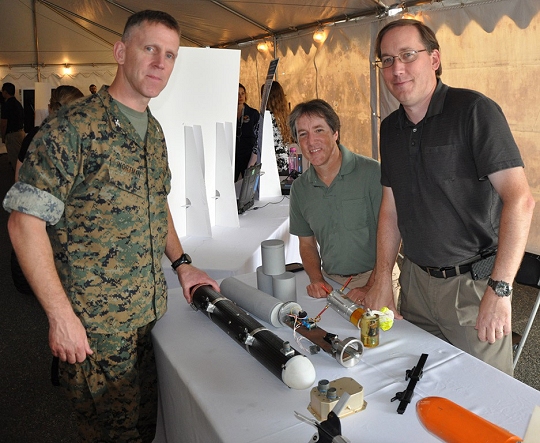 DAHLGREN, Va. (Sept. 14, 2017) - Navy engineers Gary Shearer and Ian Shafer, right, brief Marine Corps Warfighting Laboratory Commanding Officer Brig. Gen. (sel) Christian Wortman on the Multi-Purpose Unmanned Aerial Vehicle (UAV) Payload Dispenser at the 2017 Annual Navy Technology Exercise. The dispenser is compact, but scalable, and provides small tactical UAVs or other intelligence, surveillance and reconnaissance type aircraft with the ability to deploy a variety of payloads. This includes, but is not limited to, ground sensors, rescue radios, even new UAV-based weapons. (U.S. Navy photo by John Joyce/Released)