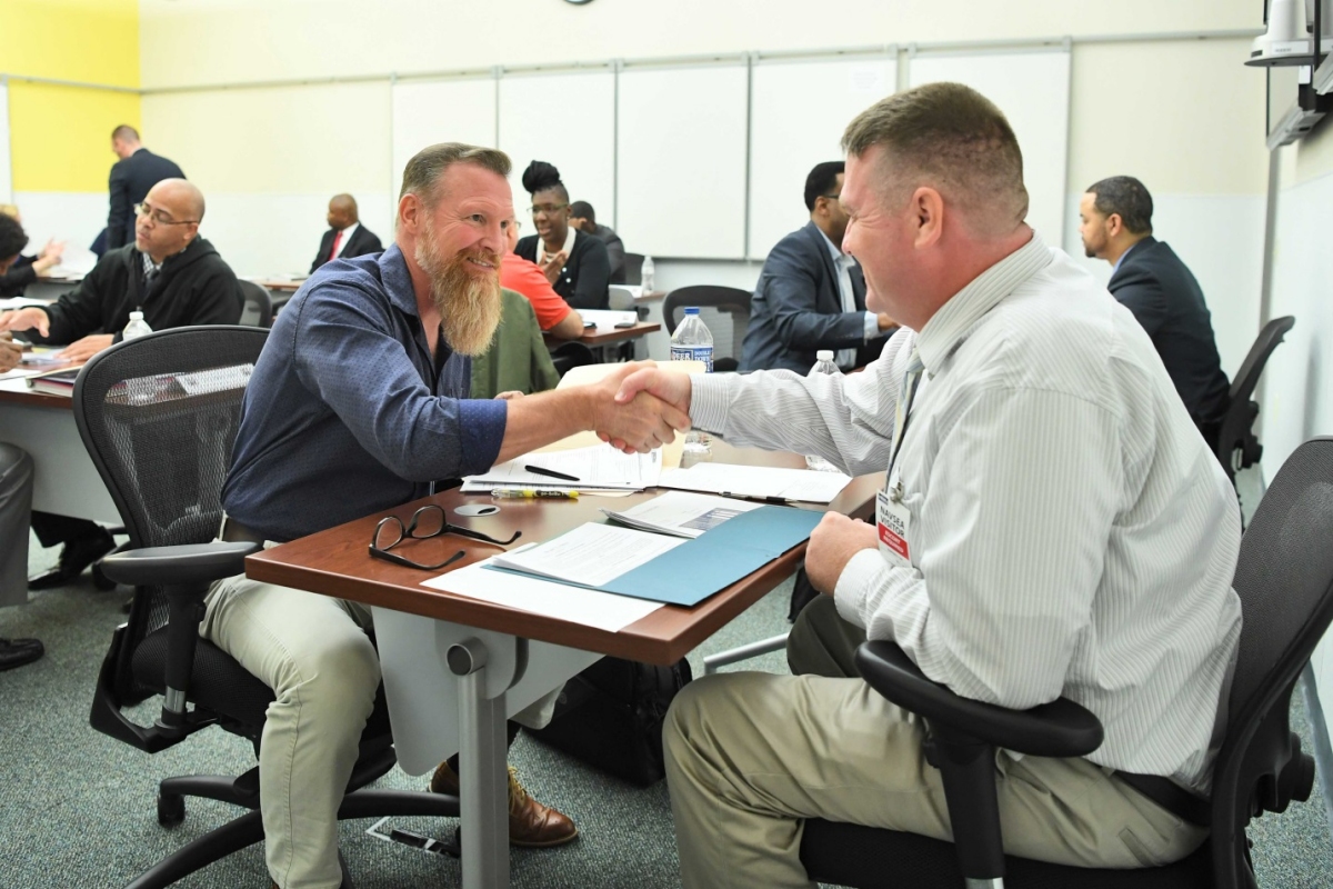 Robert Zimmerman, left, a supervisor at NSWC Indian Head EOD Technical Division, greets one of nearly 50 veteran and Wounded Warrior jobseekers during a job fair held on Oct. 18 at NAVSEA Headquarters at the Washington Navy Yard. The reverse-style career fair was one of a number of events and programs NAVSEA conducts to facilitate hiring veterans and Wounded Warriors across the enterprise.