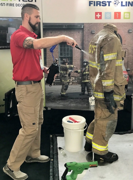 CHANTILLY, Va. - A First Line Technology employee demonstrates application of the Dahlgren Decontamination solution, known as Dahlgren Decon, for decontaminating a fire suit. The Federal Laboratory Consortium for Technology Transfer (FLC) selected Dahlgren Decon technology for a 2018 Excellence in Technology Transfer Award, Naval Surface Warfare Center Dahlgren Division (NSWCDD) announced, Feb. 2. Dahlgren Decon was invented and developed by NSWCDD to defend warfighters against chemical, biological, and radiological agents. In September 2016, the command signed an exclusive license agreement with First Line Technology, a Virginia-based small business, permitting it to manufacture the life-saving decontamination technology for warfighters and first responders nationwide.