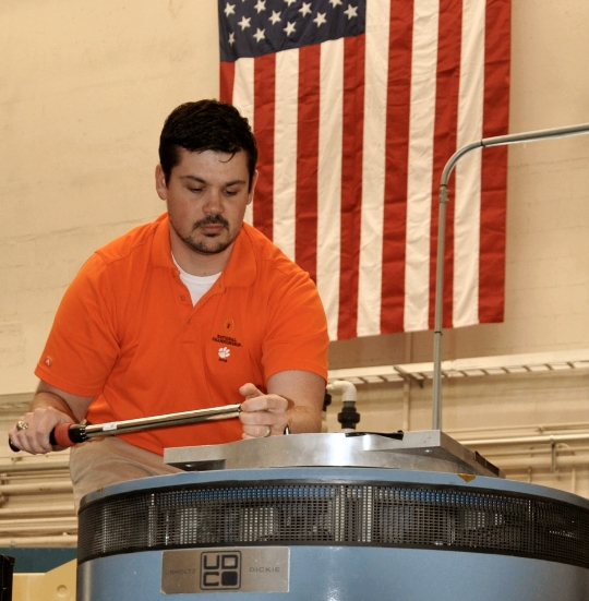 DAHLGREN, Va. - Naval Surface Warfare Center Dahlgren Division (NSWCDD) engineer Shawn Schneider mounts an adapter plate to an Unholtz-Dickie T-2000 electro-dynamic vibration system capable of providing over 24,000 pounds of force in vibration at frequencies up to and exceeding 3,000 hertz (cycles per second). These systems are used to replicate shock and vibration environments experienced by test items during their lifecycle to ensure that performance and safety are not compromised prior to use by the warfighter. NSWCDD announced on March 20 that Schneider won the 2018 Department of the Navy Award for Technical Excellence at a Test and Evaluation Facility or Range. The engineer was honored for extraordinary scientific and engineering contributions to the test and evaluation community in the area of multi-input-multi-output vibration test profiles. (U.S. Navy photo by John Joyce/Released)