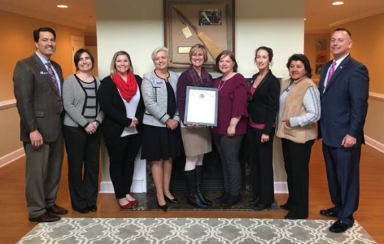 Pictured left to right: Bill Gaines (President of Calvert Hospice Board of Directors), Amanda Peterson (Communications & Volunteer Coordinator), Lindsay Falcone (Assistant Director of Clinical Operations), Claire Piason (Director of Development), Amy Szatanek (Director of Patient & Family Services, Director of Burnett Calvert Hospice House), Kara Rawlings (Director of Clinical Operations), Sarah Simmons (Director of Quality & Education), Lilian Lopez (CFO), and Steve McAdams (Executive Director of the Governor's Office of Community Initiatives). Not pictured: Jean Fleming (Executive Director).