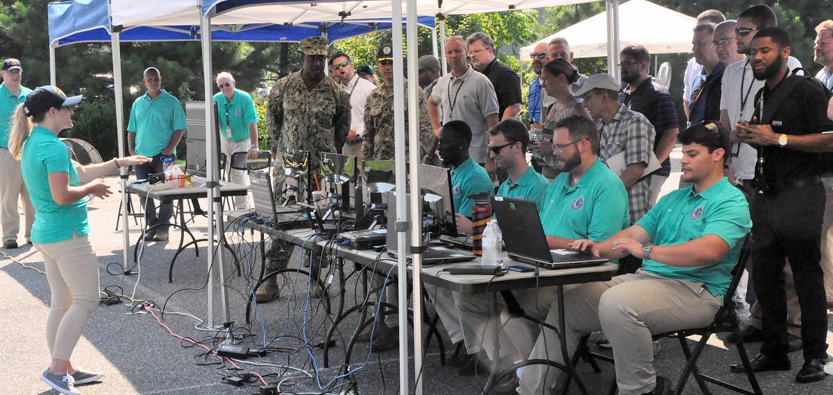 DAHLGREN (Aug. 7, 2018) - Kim Wendt - a Naval Surface Warfare Center Dahlgren Division (NSWCDD) software engineer - briefs military personnel and senior scientists and engineers about the Sly Fox Mission 23 demonstration known as the Autonomous Remote Tactical Engagement Multi-Domain Intelligence Swarm (ARTEMIS). Wendt was among seven junior scientists and engineers (less than two years out of college) who developed ARTEMIS to engage in enhanced ISR missions using unmanned ground vehicles (UGVs), artificial intelligence, and machine learning to detect targets efficiently and effectively. While the use of UGVs met the requirements set forth by Mission 23, the team envisions a more complex system that expands to the aerial domain.