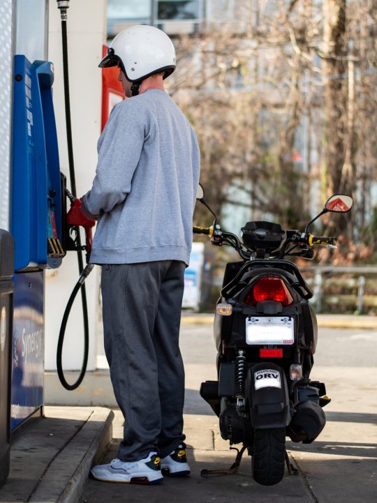 University of Maryland student King Ripley, buying gas Tuesday before heading to class, gets great mileage on his scooter, but said even he has felt the increased prices. (Photo: Joe Ryan)